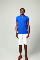 Full length portrait of a smiling african man on gray background