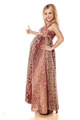 Pregnant woman in a long dress showing thumbs up