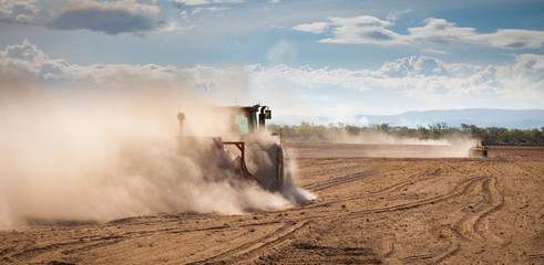 Tractor plowing dry land - obrazy, fototapety, plakaty