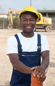 Standing african construction worker with pipe