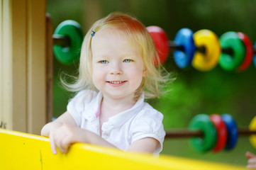 Fototapeta na wymiar Little girl having fun at a playground