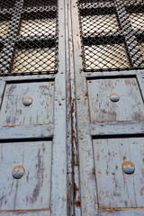 Old door with bars in the sunlight