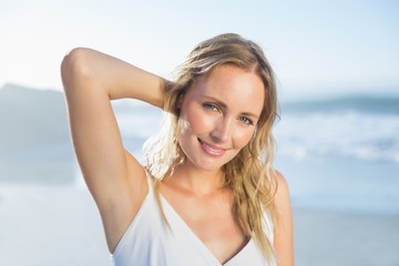 Pretty blonde standing at the beach in white sundress - obrazy, fototapety, plakaty