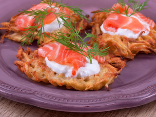 Golden potato fritters with salmon served with creamy sauce