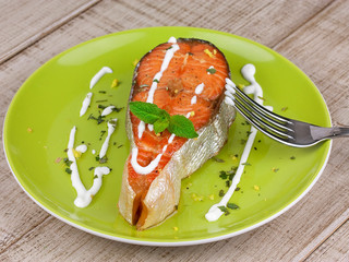 Grilled salmon served with creamy sauce and mint