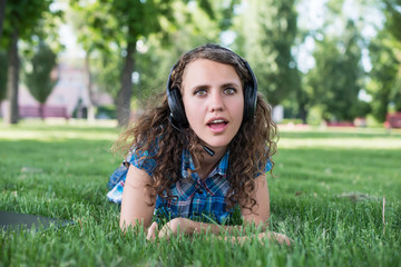 Close up portrait of Pretty young girl listening music lying