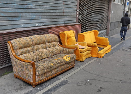 Canapé et fauteuils jaunes jetés dans la rue.