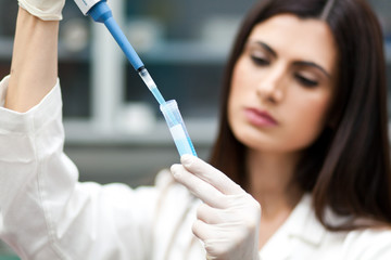 Female researcher filling a test tube