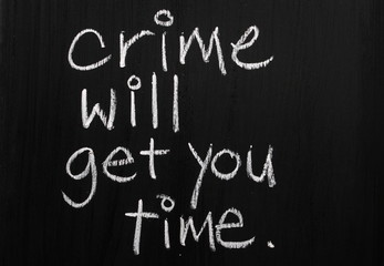 Fototapeta na wymiar Crime Will Get You Time written on a blackboard