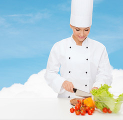 smiling female chef chopping vegetables