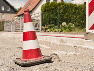 Fototapeta na wymiar Strassenbauarbeiten - Eine Pilone warnt vor einer Gefahrenstelle