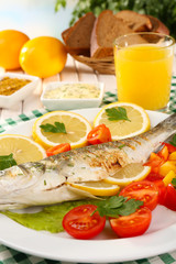 Delicious grilled fish on plate on table close-up