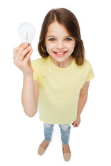 smiling little girl holding light bulb