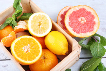 Fototapeta na wymiar Fresh citrus fruits with green leaves in wooden box