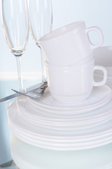 Set of white dishes on table on light background