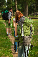 Fototapeta premium Three Tourists Walking Through The Woods