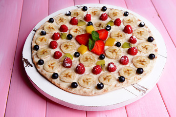 Sweet pizza with fruits on table close-up
