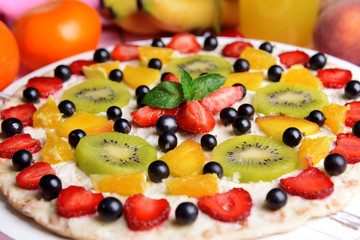 Sweet pizza with fruits on table close-up