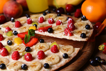 Sweet pizza with fruits on table close-up