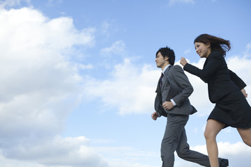走るビジネスマンとビジネスウーマン