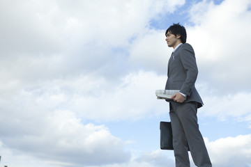 新聞を持って立つビジネスマン