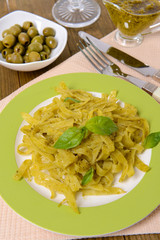 Delicious pasta with pesto on plate on table close-up