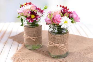 Beautiful bouquet of bright flowers in jars