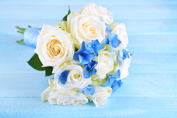 Beautiful wedding bouquet with roses on blue wooden table