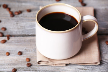 Cup with hot coffee and roasted coffee grains