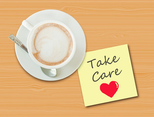Coffee cup on wood table with paper note