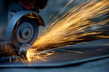 Worker cutting metal with grinder - obrazy, fototapety, plakaty