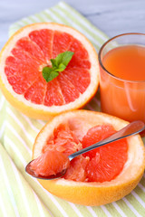 Ripe grapefruits on cutting board, on wooden background