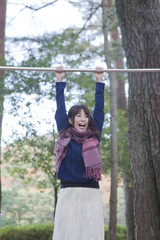 Fototapeta premium 公園の鉄棒で逆上がりをしようとする女性