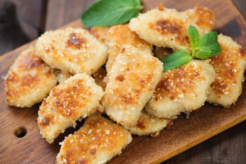 Sesame chicken nuggets on a rustic wooden cutting board