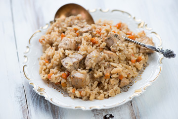 Pilaf with chicken, white wooden background, horizontal shot