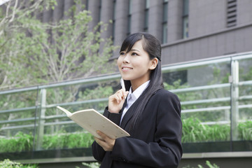 ノートを見て考えるビジネスウーマン