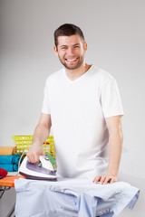 Smiling man ironing