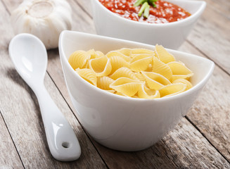 Tomato sauce and pasta on wooden background