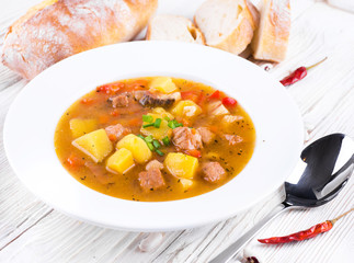 .Hungarian goulash with beans and peppers on wooden board