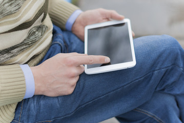 Man with tablet in hand on the street.