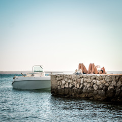 Couple resting on a pier by the sea