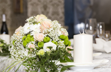candle and bouquet on table in restaurant