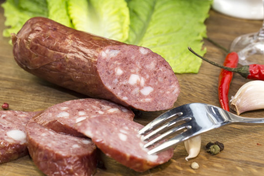 sausages on a wooden plate with vegetables in a restaurant