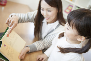 Obraz premium 母親と本を読む女の子