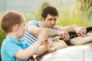 Father and son repairing car