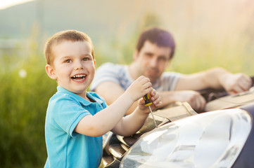 Father and son repairing car