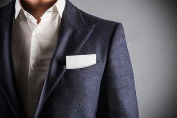 man wearing suit. business card in the pocket