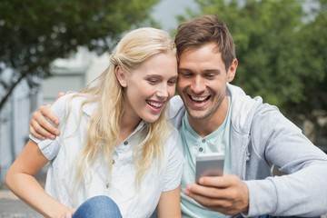 Hip young couple looking at smartphone