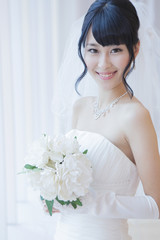 Naklejka premium ブーケを持ったウエディングドレス姿の女性