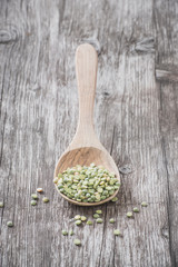 Organic split peas on a wooden spoon